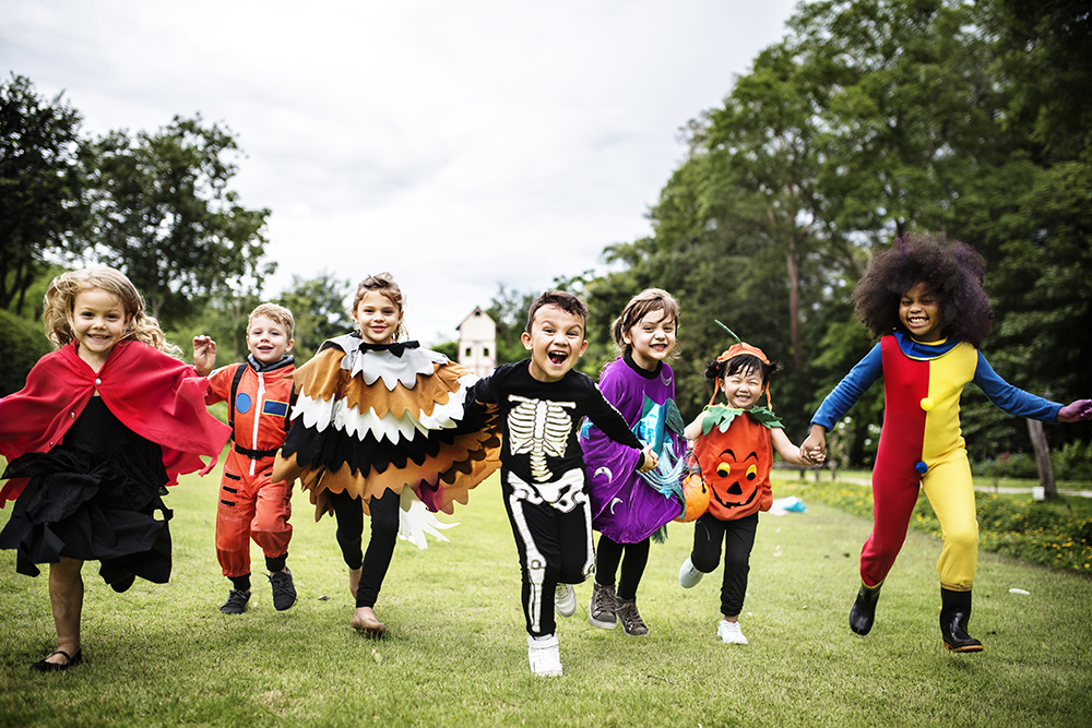 A group of kids outdoors in halloween costumes.