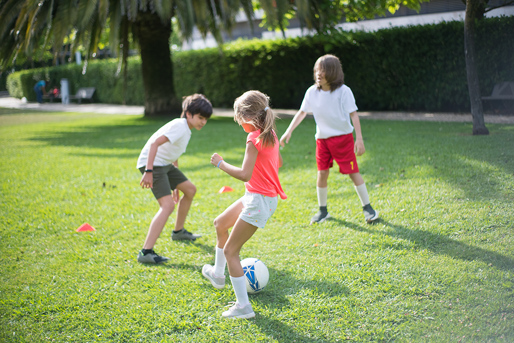 Kids playing football outdoors.